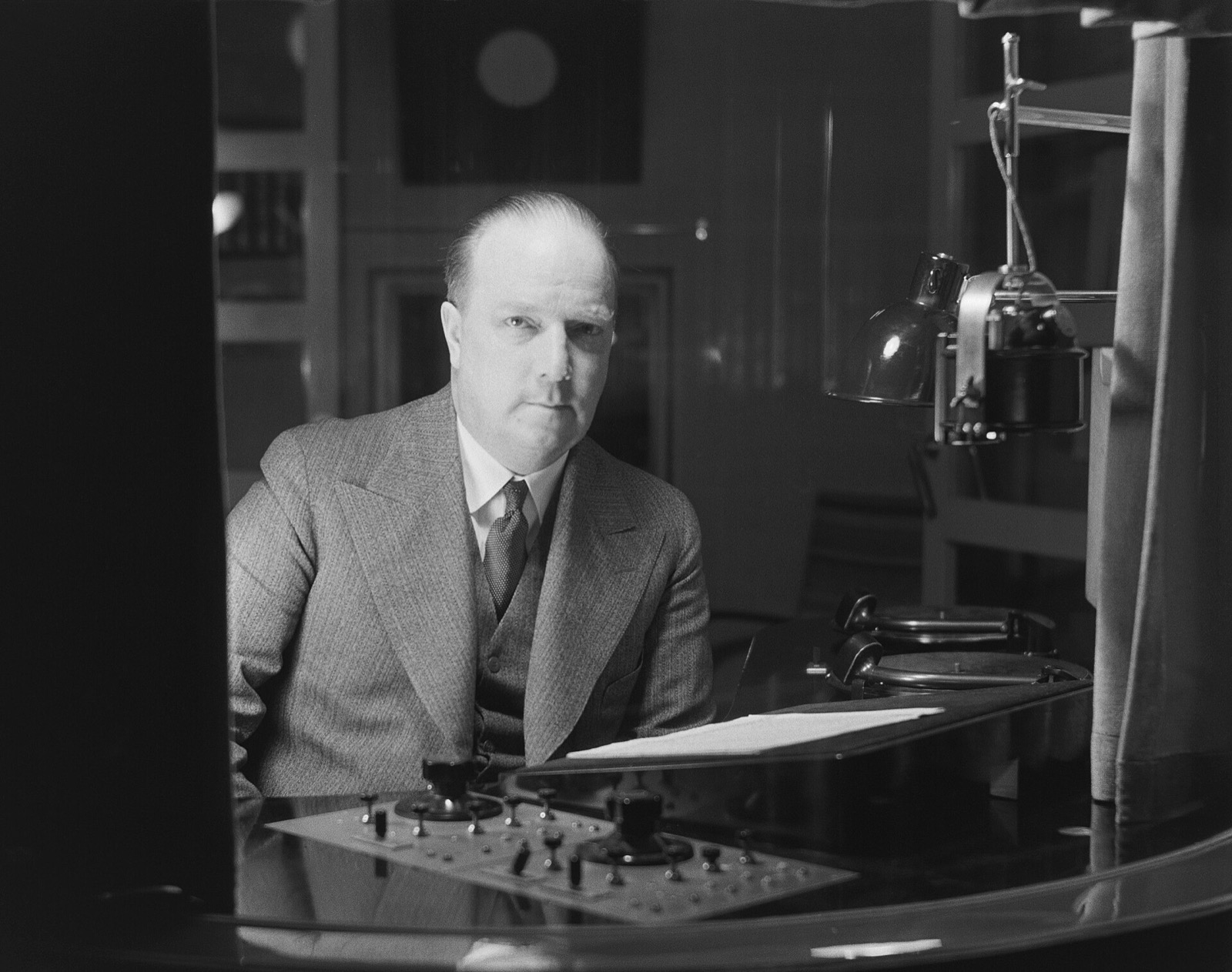A radio announcer at his desk in the studio, about 1930.